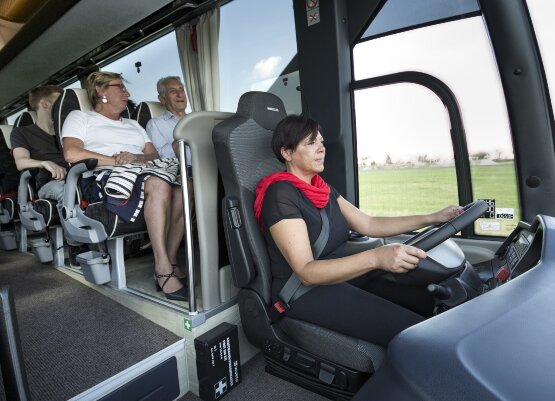 Gruppe mit Busfahrerin im Reisebus